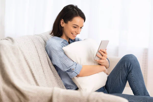 Menina feliz tendo descanso em casa usando o telefone — Fotografia de Stock