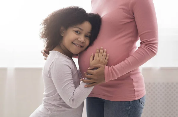 Bonito pouco preto menina abraçando e tocando grávida mães barriga — Fotografia de Stock