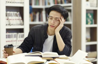 Stressed chinese guy sleeping in modern library