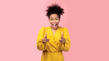 Happy black woman choosing you over pink background