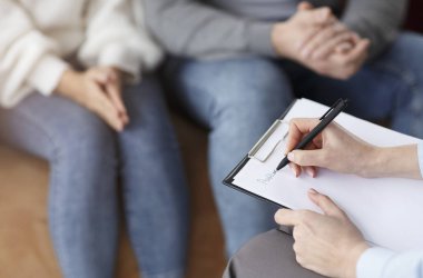 Marriage Consultant Taking Notes Talking With Couple In Office, Cropped