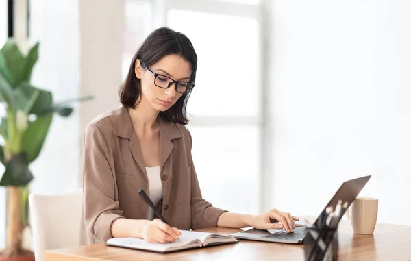 Portrait of concentrated manager writing in notebook — Stockfoto