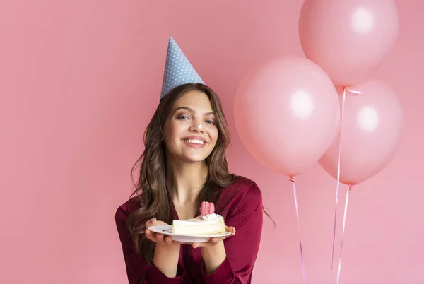 Drôle fille posant avec morceau de gâteau sur fête d'anniversaire — Photo