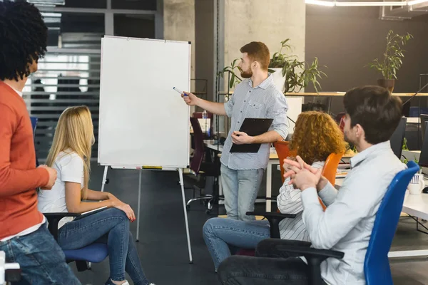 Young man presenting new marketing plan to creative team — Stockfoto
