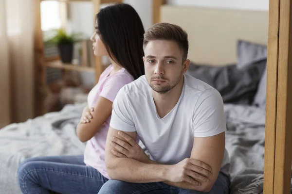 Offended Couple Sitting On Different Sides Of Bed At Home — Stockfoto