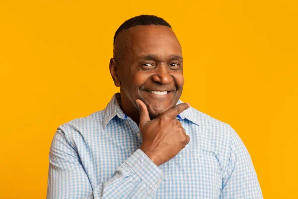 Flirty middle aged african man smiling at camera — Stockfoto