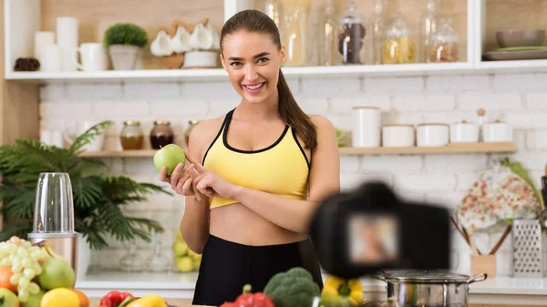 Fit blogger with fruits recording new video in kitchen — Stock Fotó