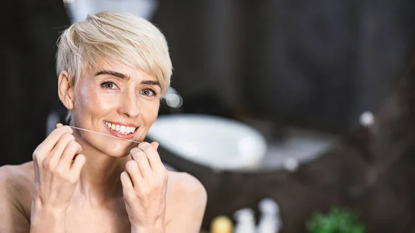 Woman Flossing Perfect White Teeth Smiling To Camera In Bathroom — Stok fotoğraf