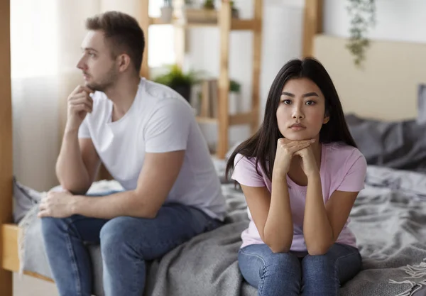 Triste asiático esposa sentado con no amado marido en cama interior —  Fotos de Stock