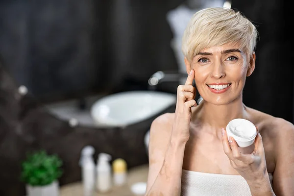 Gorgeous Woman Applying Facial Cream Standing In Bathroom At Home — 图库照片