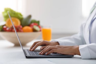 Side view of nutritionist working on laptop at office