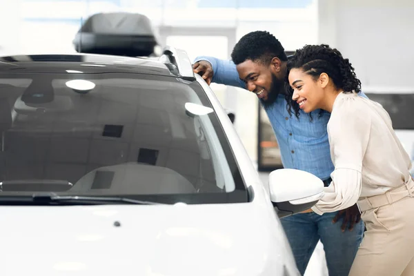 Marido e esposa escolhendo novo automóvel juntos na loja de concessionárias — Fotografia de Stock