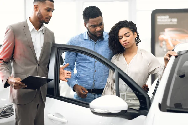 Displeased Car Buyers Choosing Automobile With Seller In Dealership Store — Stock Photo, Image