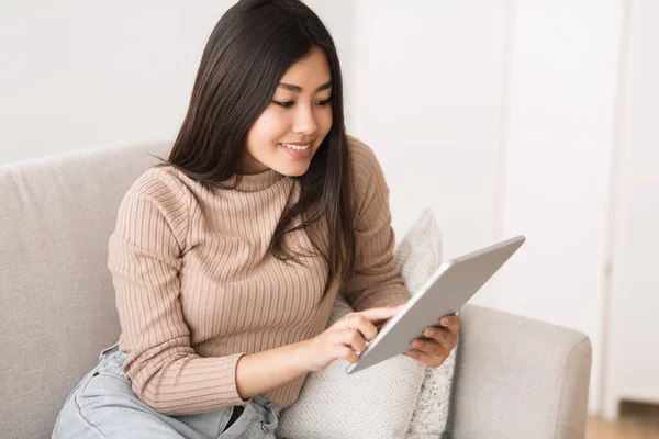 Conteúdo interessante. Menina asiática lendo blog no tablet digital — Fotografia de Stock