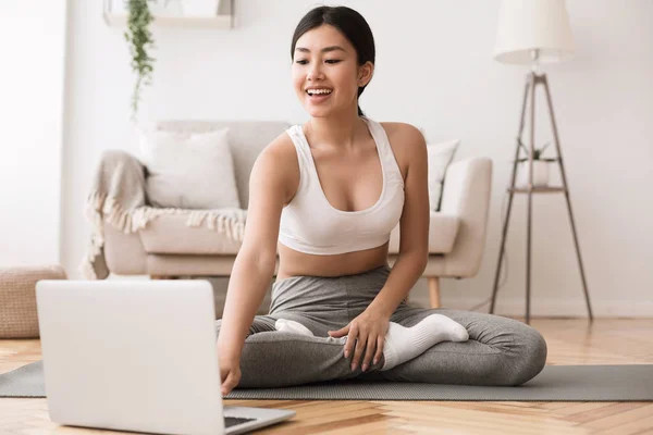 Sporttoepassing. Aziatisch meisje oefenen yoga en met behulp van laptop — Stockfoto