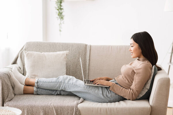 Онлайн-образование. Азиатка с ноутбуком дома
