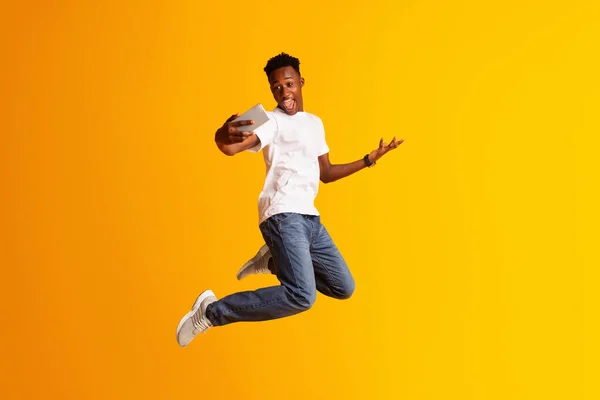 Handsome african guy making selfie while jumping — Stockfoto