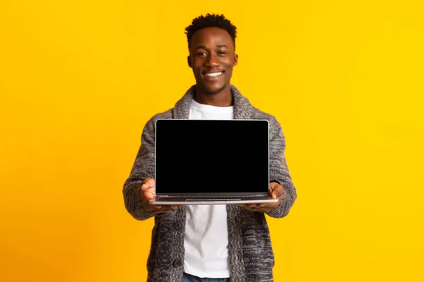Joven emocionado hombre africano alegre sosteniendo en las manos portátil —  Fotos de Stock