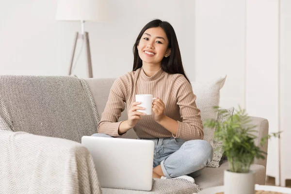 Bom fim de semana. Menina asiática relaxante, beber café e usando laptop — Fotografia de Stock