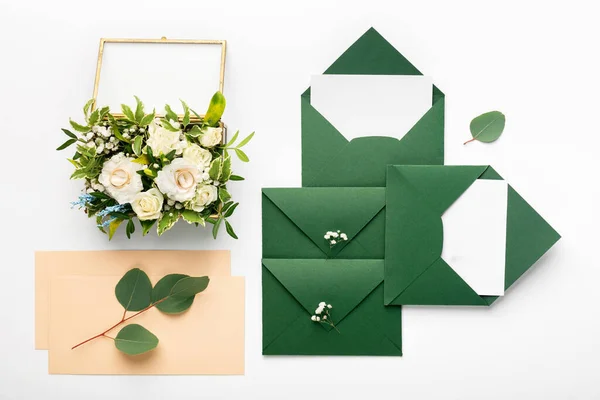 Svatební pohlednice nebo pozvánky, snubní prsteny a zelené obálky — Stock fotografie