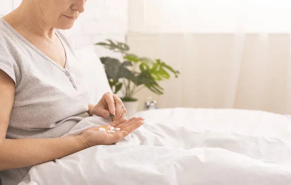 Oudere vrouw neemt elke dag medicatie in bed — Stockfoto