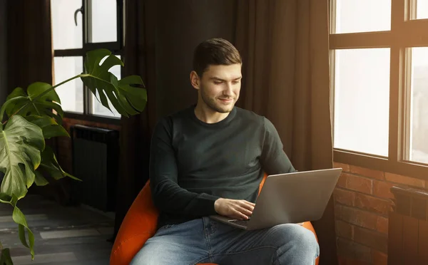 Jongeman werkt op laptop surfen op internet zitten thuis — Stockfoto