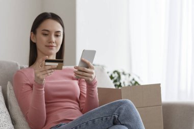 Başarılı genç kadın mobil banka kullanarak işlem yapıyor.