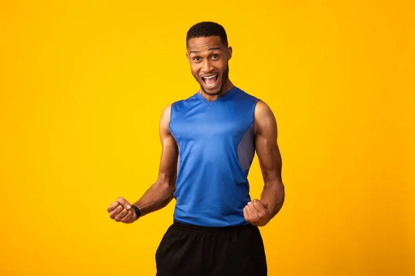 Feliz hombre afro celebrando el éxito gestual en el estudio amarillo —  Fotos de Stock