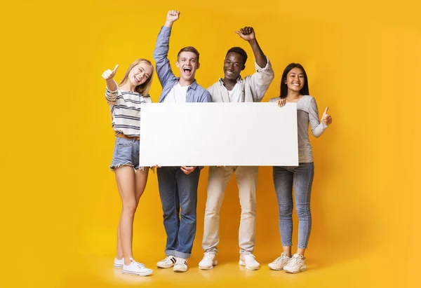 Emocionado grupo de adolescentes sosteniendo plackard blanco vacío —  Fotos de Stock