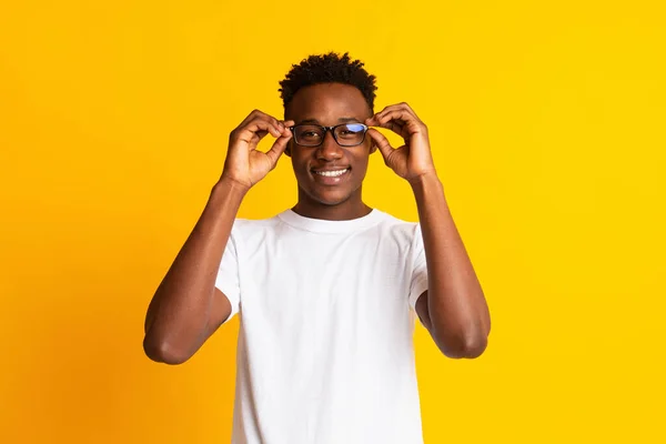 Guapo afroamericano estudiante chico usando gafas y sonriendo —  Fotos de Stock