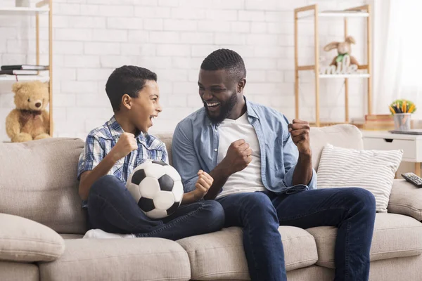 Προεφηβικό μαύρο αγόρι που βλέπει ποδόσφαιρο στην τηλεόραση με τον πατέρα του — Φωτογραφία Αρχείου