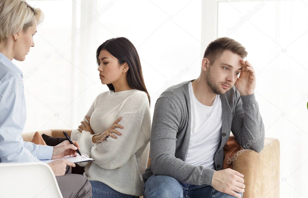 Indifferent Spouses Having Conflict Sitting Back-To-Back In Psychologists Office