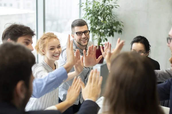 Colleagues Giving High-Five Celebrating Business Success Standing In Office  Stock Photo by ©Milkos 381522740