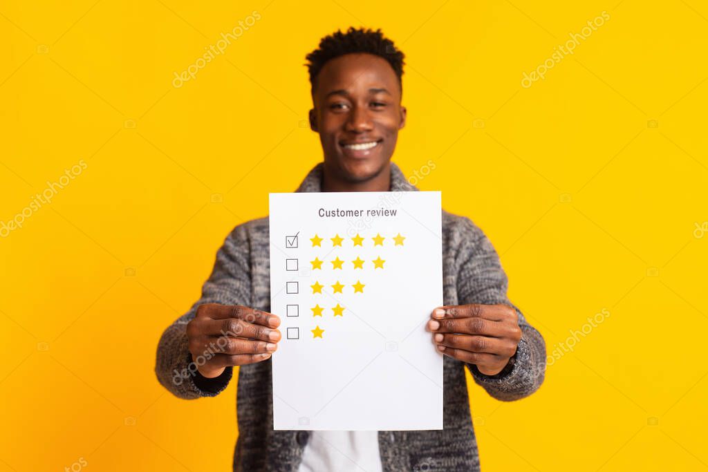 Young smiling african man is pointing on five stars rating