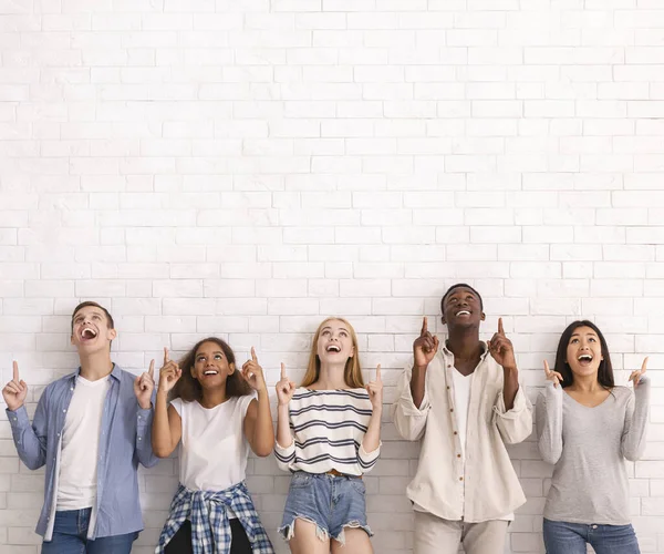 Grupo de amigos multirraciais apontando para o espaço de cópia — Fotografia de Stock