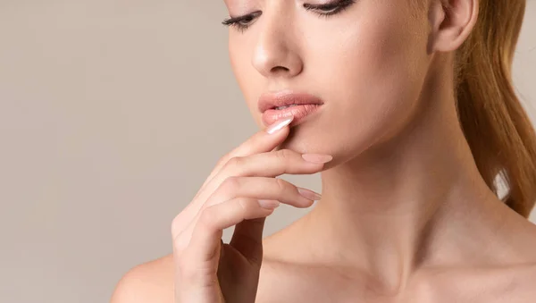 Sensual chica tocando labios posando sobre Beige Studio fondo, recortado —  Fotos de Stock