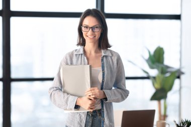 Modern ofiste kameraya bakan mutlu bir yönetici.