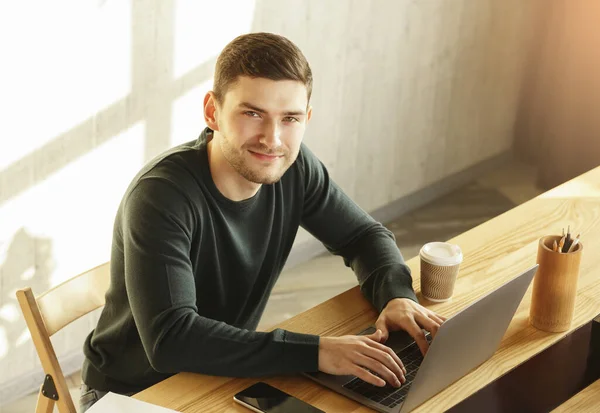 Χαρούμενος υπάλληλος που εργάζεται σε φορητό υπολογιστή στο γραφείο εργασίας στο γραφείο — Φωτογραφία Αρχείου