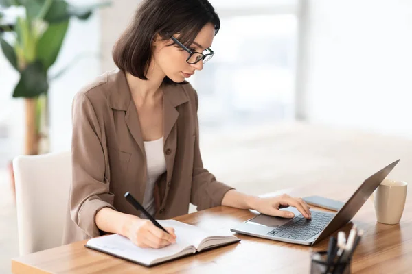 Porträtt av manager med dator och skriva i anteckningsbok — Stockfoto