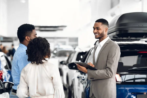 Έμπορος αυτοκινήτων άνθρωπος που πωλεί Auto μιλώντας με τους πελάτες στην αντιπροσωπεία — Φωτογραφία Αρχείου
