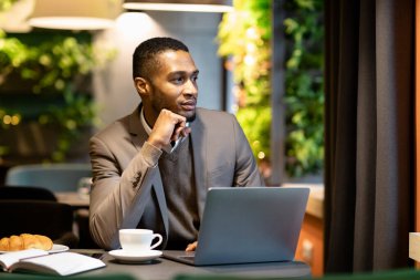 Kafede pencereden dışarı bakan Afro Yönetici