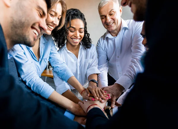 Medewerkers houden handen vast tijdens Teambuilding Meeting In Modern Office — Stockfoto