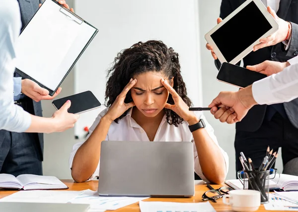 Mujer de negocios estresada en el ordenador portátil tocando la cabeza sentado en la oficina moderna — Foto de Stock
