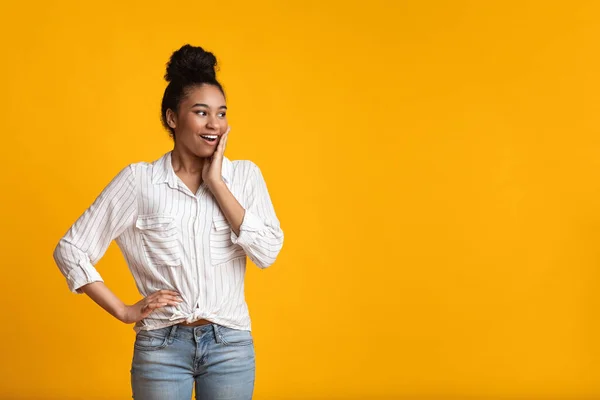 Surprised black woman opened mouth in amazement, touching cheek with excitement — Stock Photo, Image