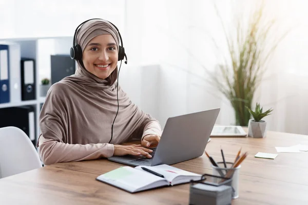 工作场所戴头巾和戴耳机的阿拉伯女性呼叫中心操作员 — 图库照片