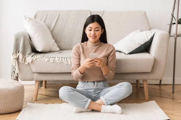 Tempo livre. Menina asiática navegando no smartphone — Fotografia de Stock