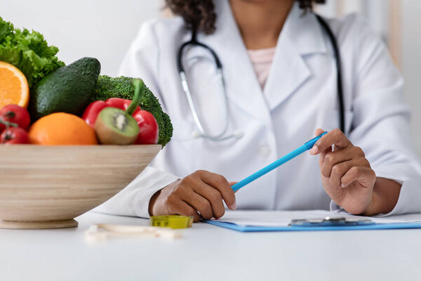 Обрезан африканской женщиной-диетологом, держащей ручку
