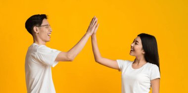Happy asian man and woman clapping their hands