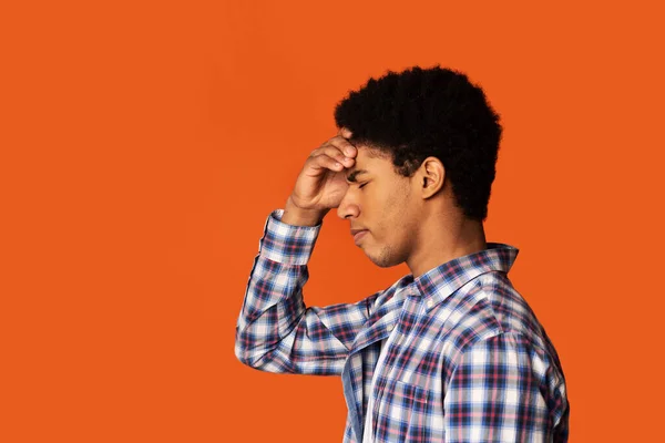 Stress, lack of inspiration or depression. African-American man thinking on color background, side view. Copy space — Stockfoto