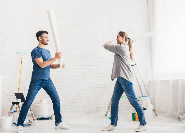 Happy young couple fighting with rollers and smiling each other — Φωτογραφία Αρχείου